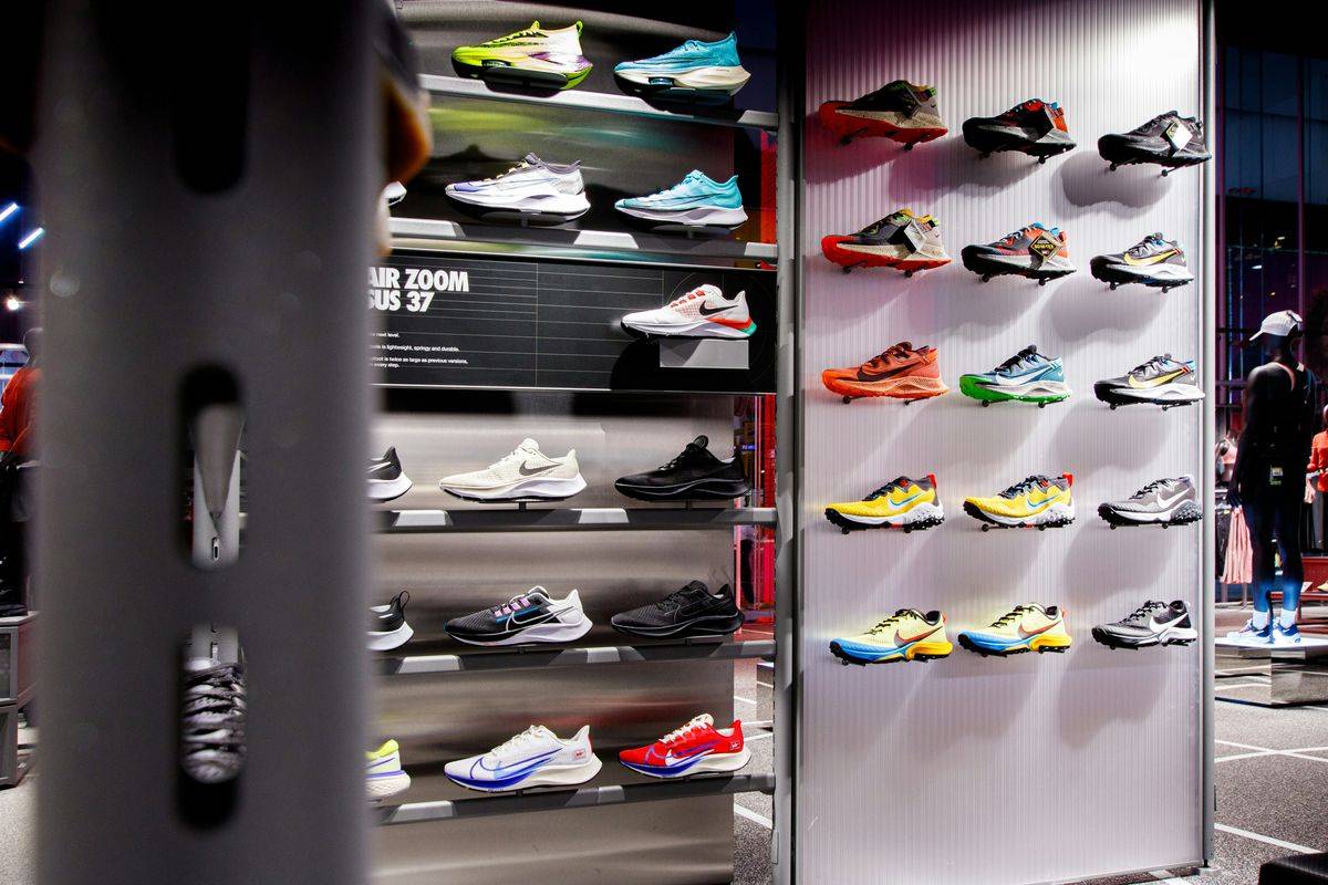 A lit wall of running shoes inside a store